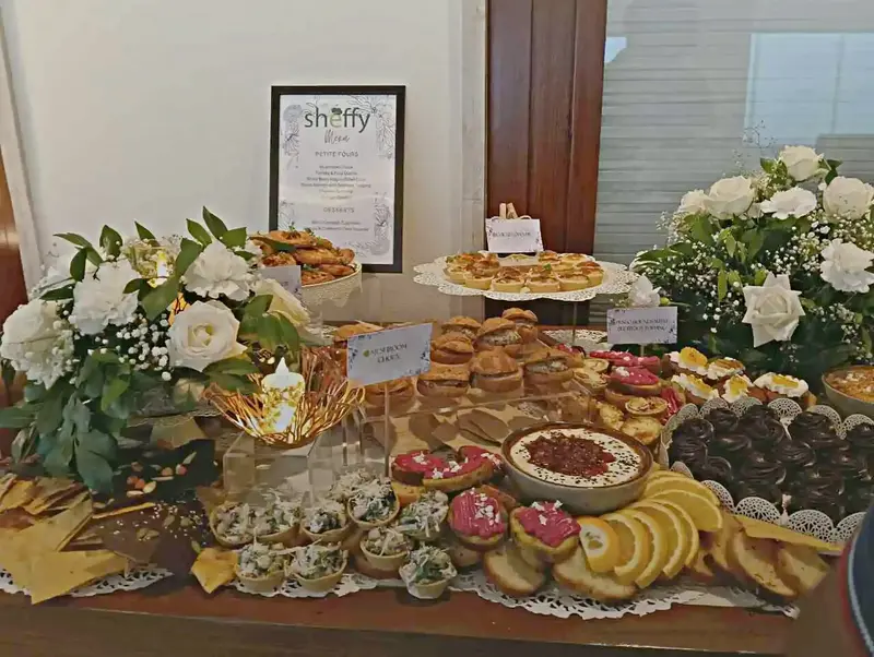 Branded Sheffy buffet spread with tiered canapes, wraps, and sandwich platters