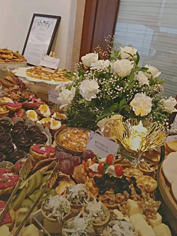 Sheffy branded dessert table with petite fours, roses, and menu card