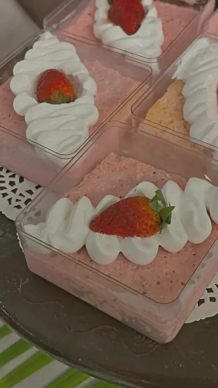 Strawberry mousse cups with whipped cream and fresh strawberry garnish
