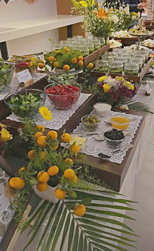 Salad bar station with fresh berries, greens, and jar dressings